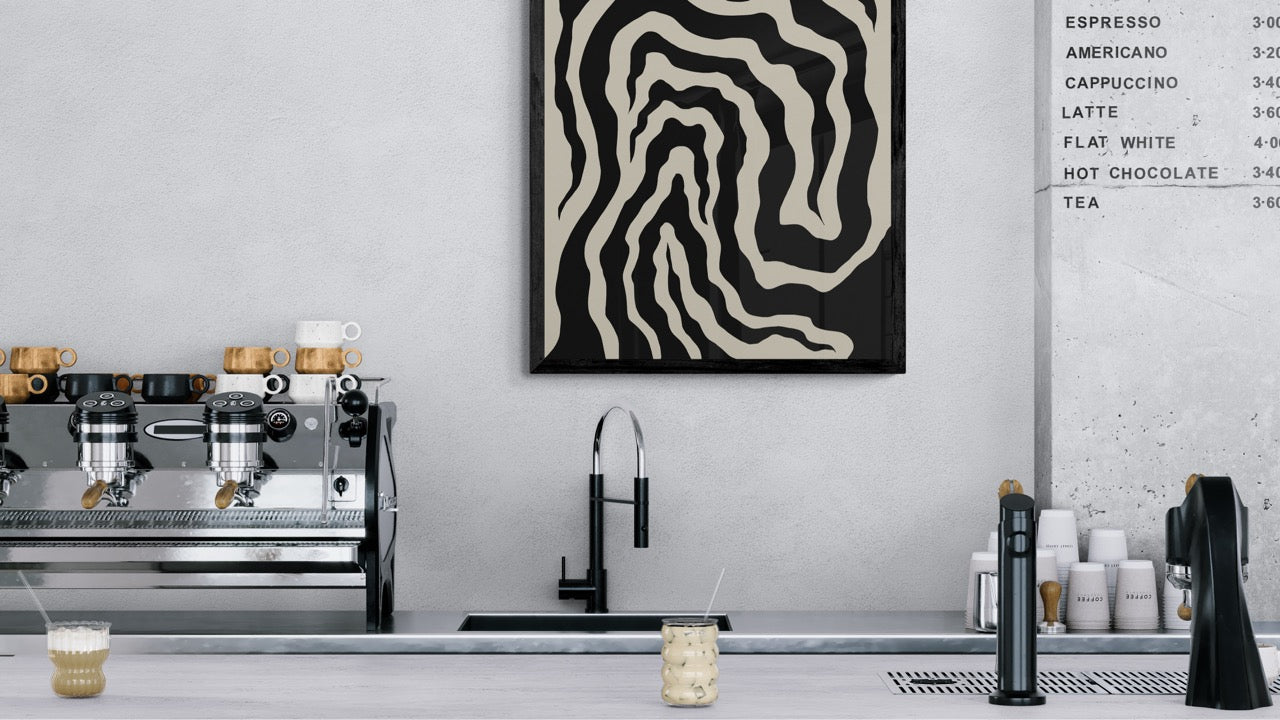 Modern kitchen with coffee machine, sink, and decorative wall art.